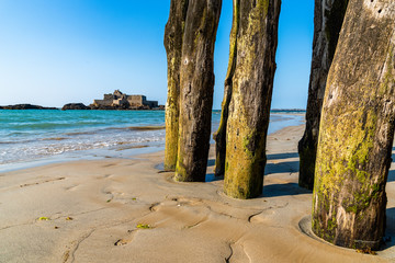 Wooden Poles outside Saint Malo walls at low tide