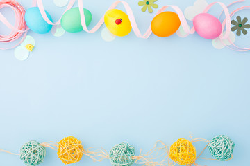 Colorful Easter eggs with decoration on a light blue background. Flat lay. Top view. Copy space