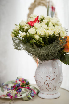 A bouquet of white roses in a vintage vase. Flowers for the holiday.