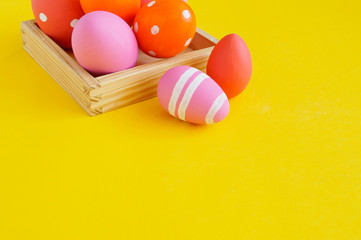 Easter eggs in a tray for eggs a stand. Yellow background.