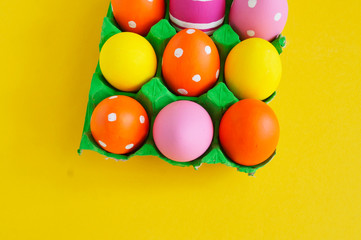 Fototapeta na wymiar Easter eggs in a tray for eggs a stand. Yellow background.