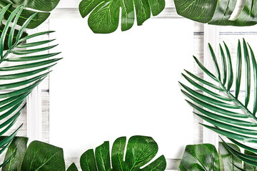 Creative layout made of tropical leaves with vintage frame.
