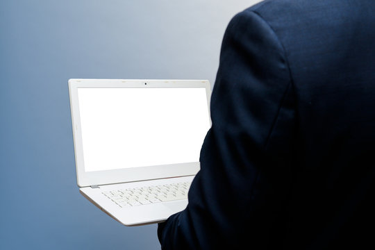 Man Using Laptop With Blank White Screen, Shot From Over Shoulder