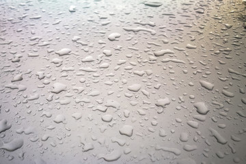 Water drops or rain on the roof of car.