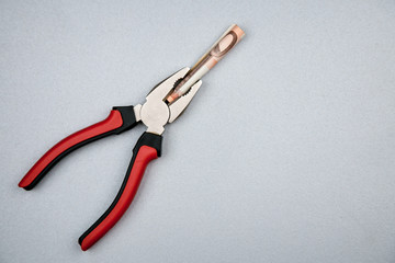 Concept of fixing currency of money and tools. Pliers and euros on a gray background