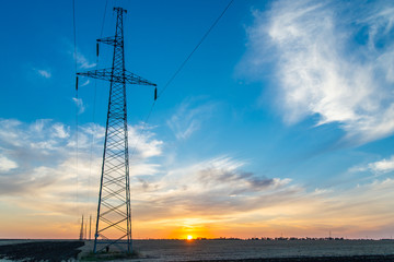Rural landscape with high-voltage line on sunset