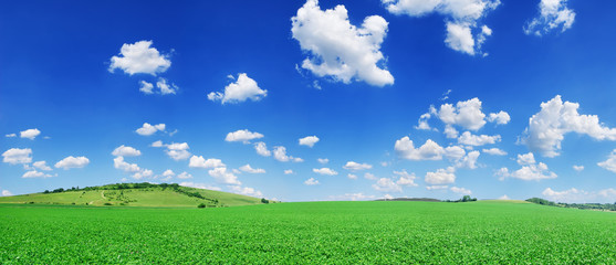 Obraz na płótnie Canvas Idyllic view, green hills and blue sky with white clouds