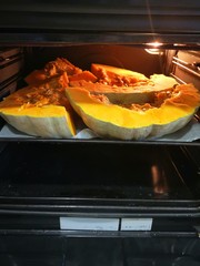 orange pumpkin cut in half in the oven