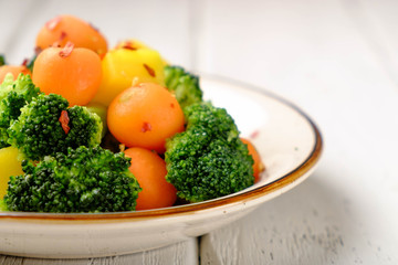 Obraz na płótnie Canvas Hot salad of broccoli, yellow carrots parisian carrot salad. Sprinkled with chili pepper