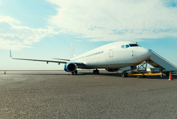 Airplane in the parking lot with fitted passenger gangway at the airport