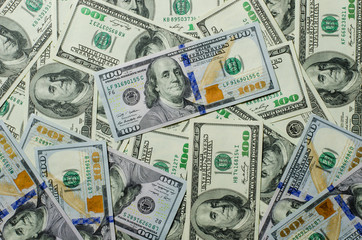 Many 100 dollar bills lying on the white background wood