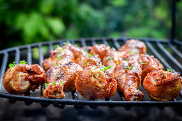 Spicy chicken leg with spices and herbs on grill