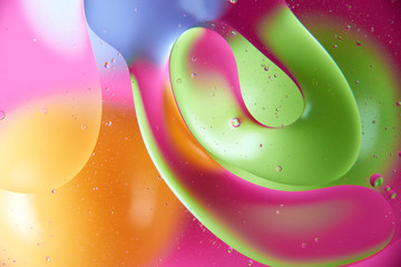 abstract background of colored drops of oil on the water