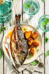 Top view of roasted seabream and potatoes with cherry tomatoes