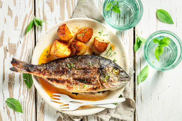 Top iew of grilled potatoes and seabream with tomatoes