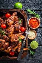 Top view of roasted chicken wings with different sauces