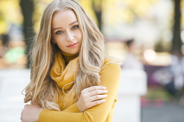 Portrait of very attractive young woman outdoor. Beautiful blond lady at urban background. Stylish female closeup portrait.