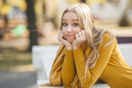 Portrait of very attractive young woman outdoor. Beautiful blond lady at urban background. Stylish female closeup portrait.