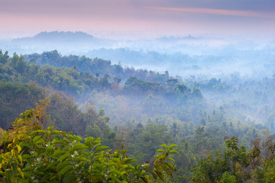 Mist hovering over Borobudur Temple at dawn, Magelang, Java, Indonesia