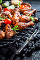 Closeup of roasted chicken wings with sauces and lime