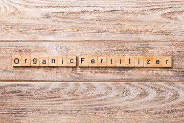 organic fertilizer word written on wood block. organic fertilizer text on wooden table for your...