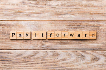 Pay It Forward word written on wood block. Pay It Forward text on wooden table for your desing, concept