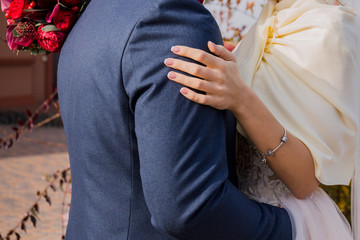 bride and groom stand together in the park in autumn