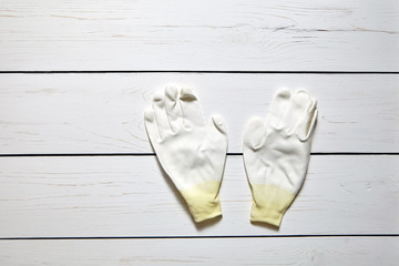 White knitted polyester yarn hand protection gloves on wooden table