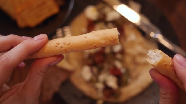 Slow motion break crispy bakery stick during meal in cafe bar
