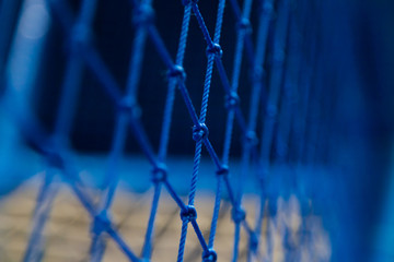 Knotted rope mesh blue netting fencing protection for safety on playgrounds, amusement rides. Selective focus - Powered by Adobe
