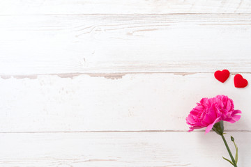 May mothers day concept photography - Beautiful carnations and hearts shape with white empty card isolated on a bright wooden table, copy space, flat lay, top view, mock up