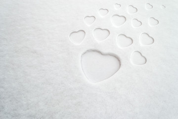 Pattern of white hearts of different sizes on fresh powder snow, with space for text. Concept for: mother's day, peace, purity, positive impact, love, romance, family, diversity, expansion.