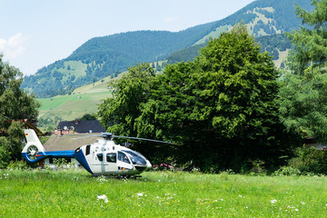 A police helicopter landed in a mountainous village in the field.