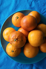 Blood oranges on table, blue background, top view.