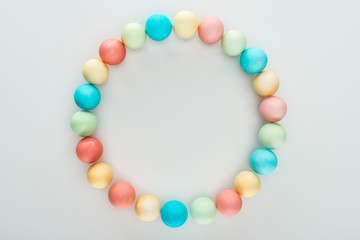 top view of colorful easter eggs as circle frame isolated on grey