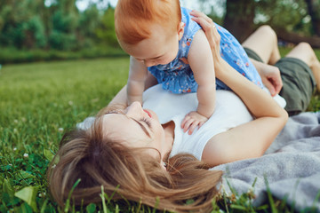 Woman with child lying on green meadow