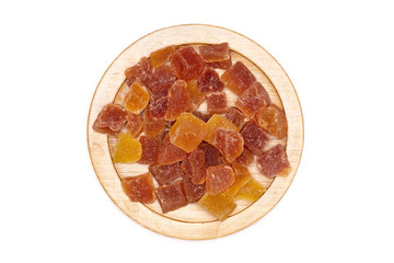 Lot of slices of dry papaya on bamboo plate flatlay isolated on white background