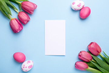 Present card , flowers tulips and easter eggs on a blue background