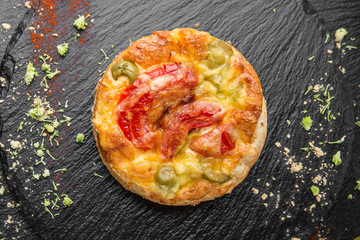 Traditional quiche pie with tomatoes, mozzarella and spinach.