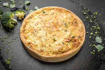 Traditional quiche pie with broccoli, salmon and cheese.