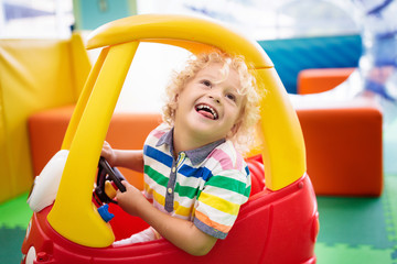 Fototapeta na wymiar Child riding toy car. Little boy with toys.