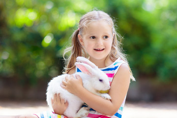 Child with rabbit. Easter bunny. Kids and pets.