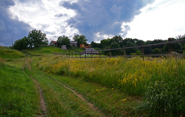 Summer landscape with unpaved roads among high green hills