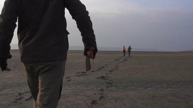 Dangerous zombie monster with big machete chasing couple of survivors in Wasteland. Horror Character post apocalyptic pursuit concept, Armed and grasepainted entity