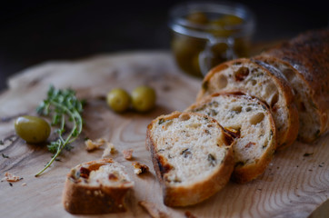 Olive bread with olives on a wooden plate
