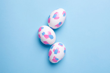 Easter eggs with watercolor brushstrokes on a blue background