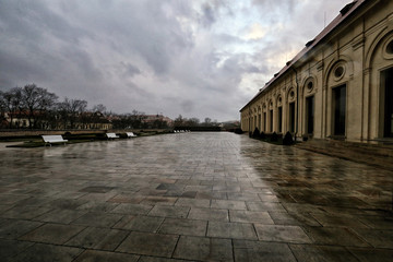 Large wet courtyard in front of beige palace