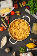 pasta, farfalle and sauce (set of ingredients). food background. copy space