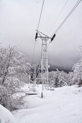 Frozen Funicular poles with ropes and snow covered scenery