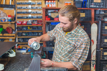 Long haired guy repairing ski in the workshop